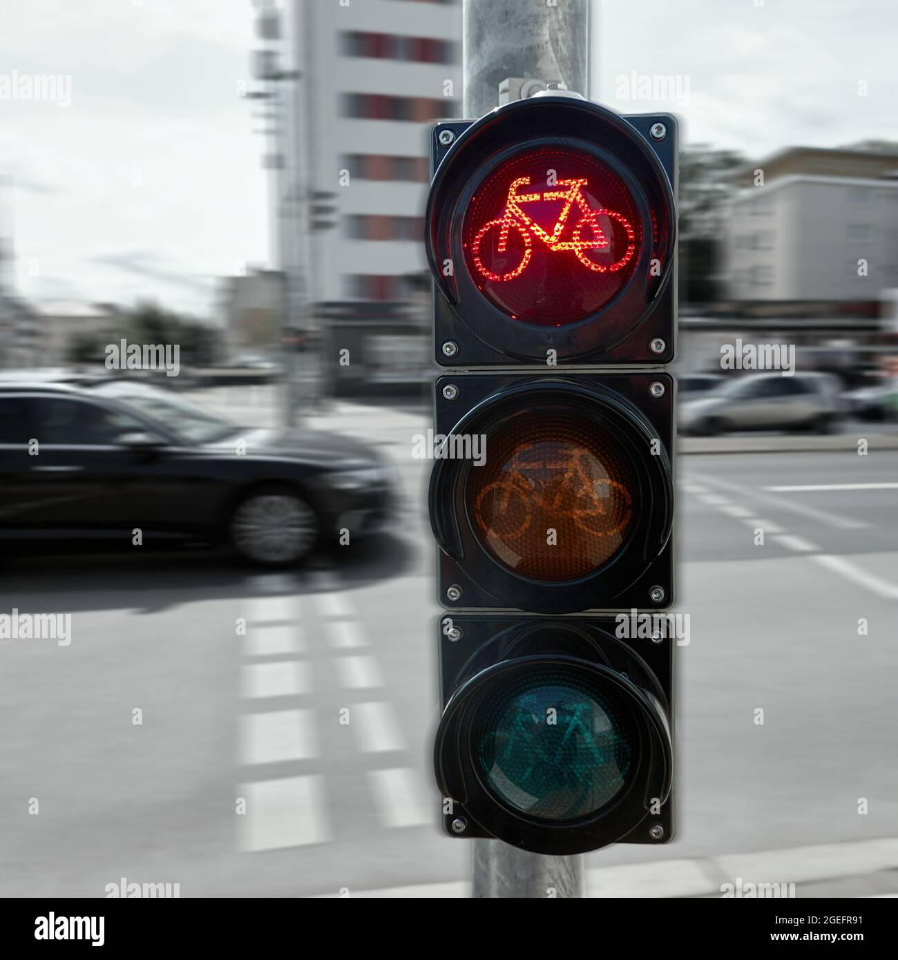 Petit feu de circulation pour les cyclistes avec un fond flou de la rue animée du centre-ville, feu supérieur rouge comme stop pour les cyclistes Banque D'Images