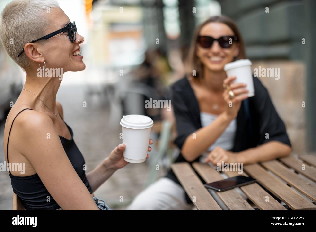 Couple féminin élégant à la terrasse du café à l'extérieur Banque D'Images