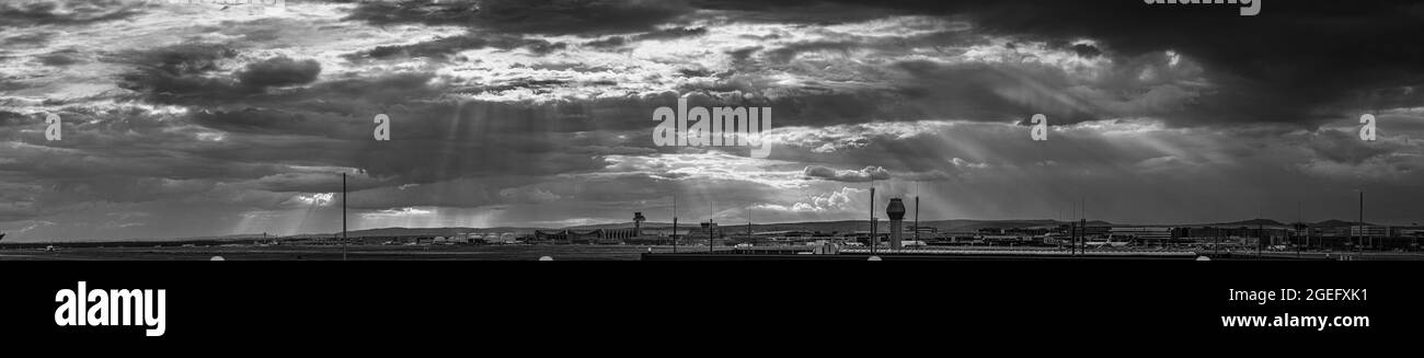 Panorama en noir et blanc de l'aéroport de francfort contre un ciel impressionnant avec des formations de nuages sauvages et des rayons du soleil Banque D'Images