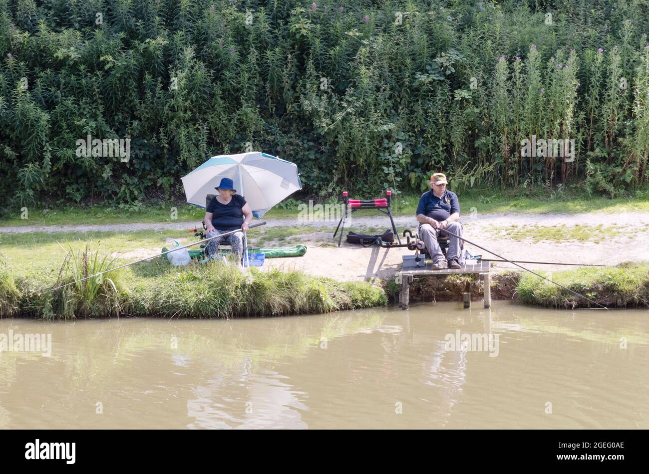 Pêche à la ligne au Royaume-Uni; deux pêcheurs à la ligne pêchant sur la rive du lac, Folly Lake, Risby, près de Beverley, dans le Yorkshire de l'est du Royaume-Uni Banque D'Images