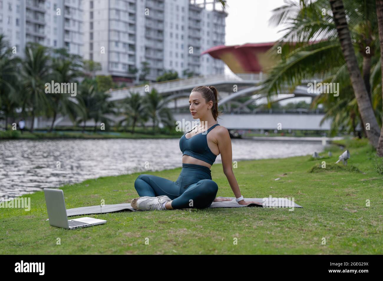 Exercice de yoga - une femme faisant du yoga pose la méditation dans le parc public. Sport sain concept. De belles formes. Banque D'Images