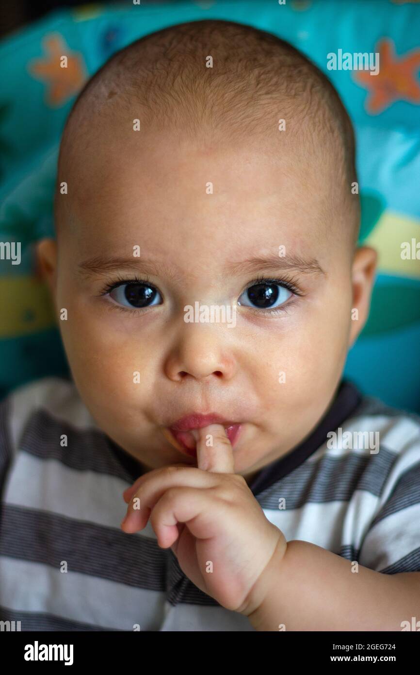 Bebe Drole Avec Un Doigt Dans La Bouche Bebe Mignon Dans Une Chaise De Bebe Photo Stock Alamy