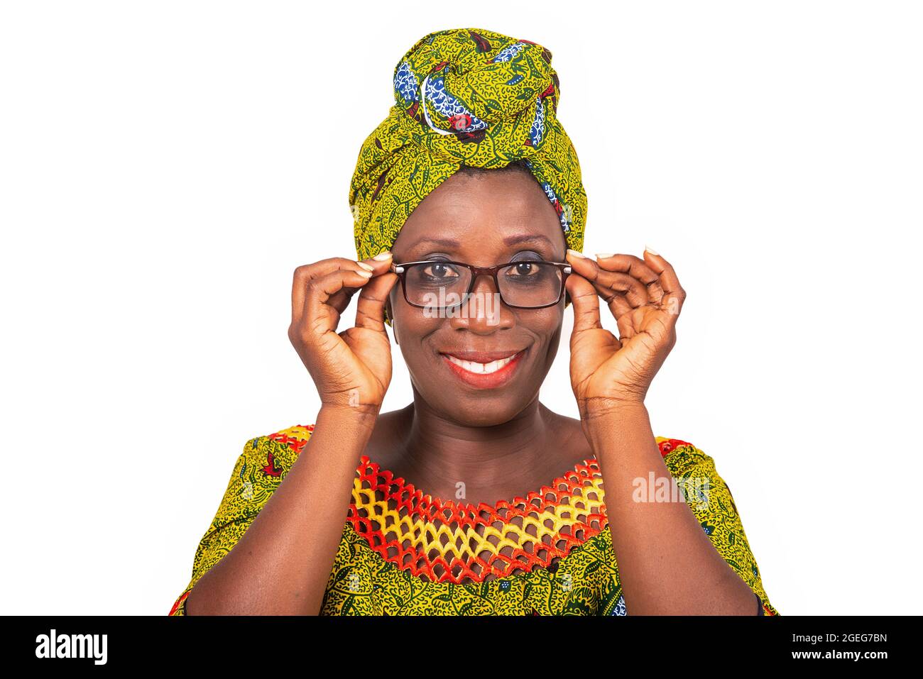 belle femme adulte africaine vêtue de tissu vert porte de belles lunettes avec les yeux souriants Banque D'Images