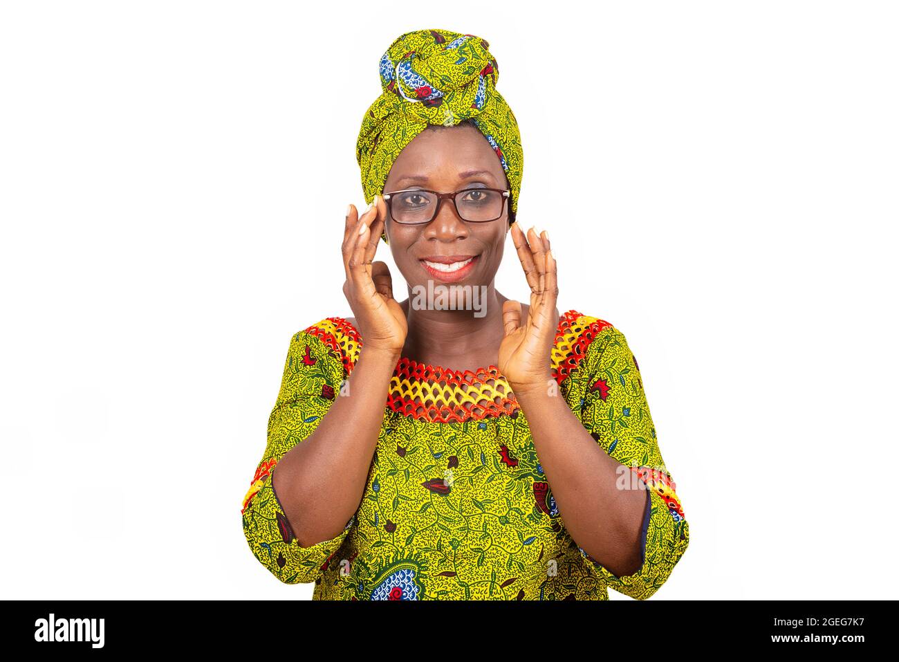belle femme adulte africaine vêtue de tissu vert portant de belles lunettes avec les yeux souriants Banque D'Images
