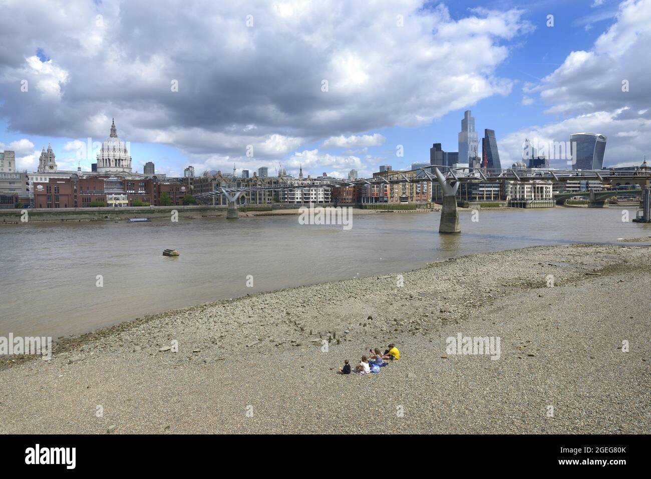 Londres, Angleterre, Royaume-Uni. Personnes sur la plage sur la rive sud de la Tamise à marée basse, en regardant vers la cathédrale St Paul et la ville de Londres Banque D'Images