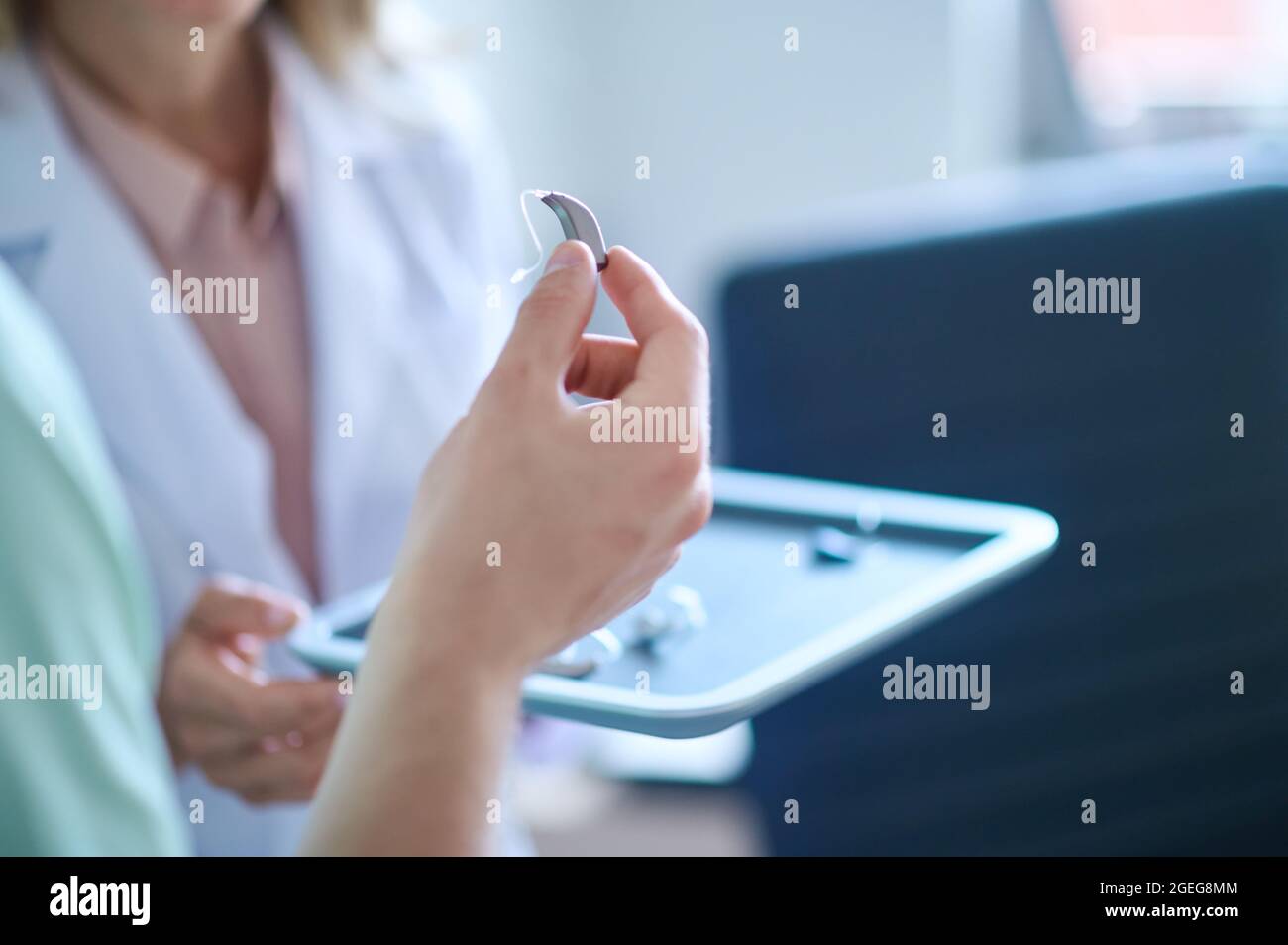 Main tenant le dispositif auditif de prélèvement Banque D'Images