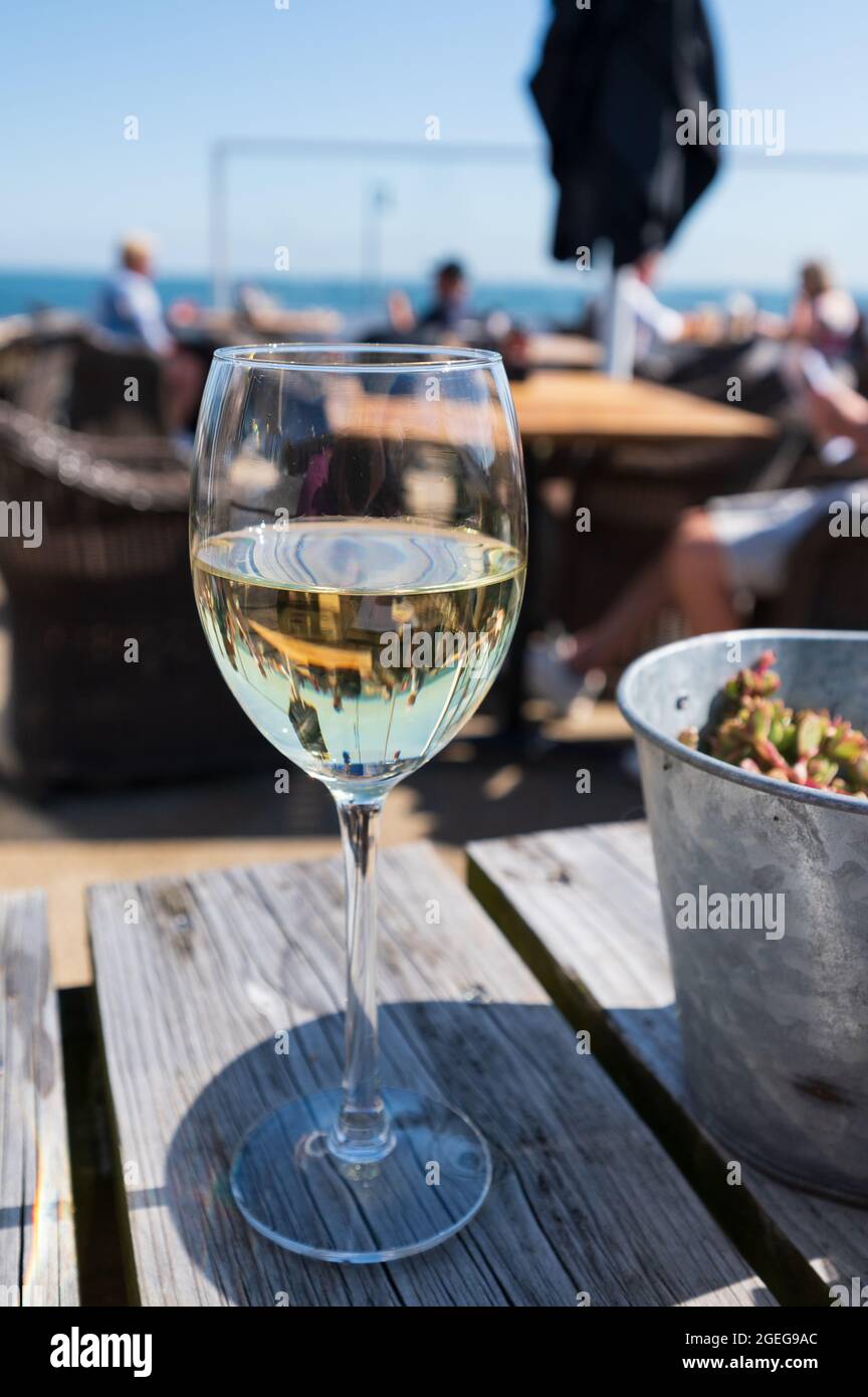 Verre de vin blanc servi sur la terrasse extérieure avec vue sur la mer,  jour ensoleillé, vacances d'été Photo Stock - Alamy