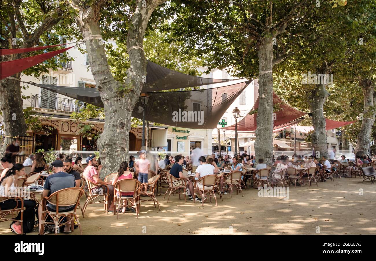 L'Ile Rousse, Corse, France - 19 août 2021 : les vacanciers se détendent devant le café de Platanes à l'ile Rousse, dans la région de Balagne en Corse Banque D'Images