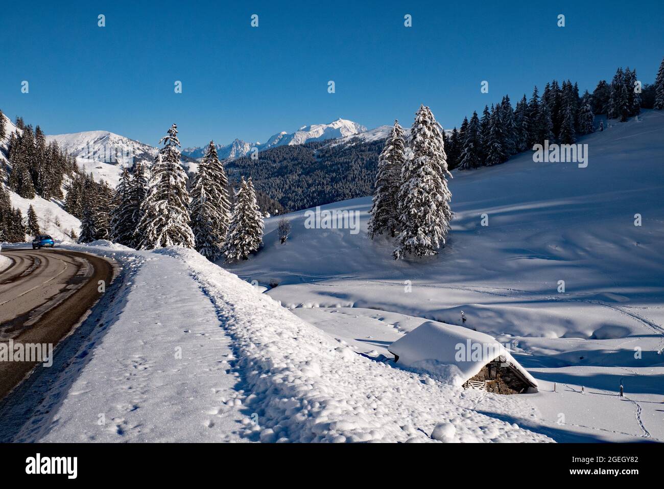 La Clusaz (Alpes, centre-est de la France) : paysage montagneux avec chalets couverts de neige dans la station de ski, vue de la route menant à l'ap Banque D'Images