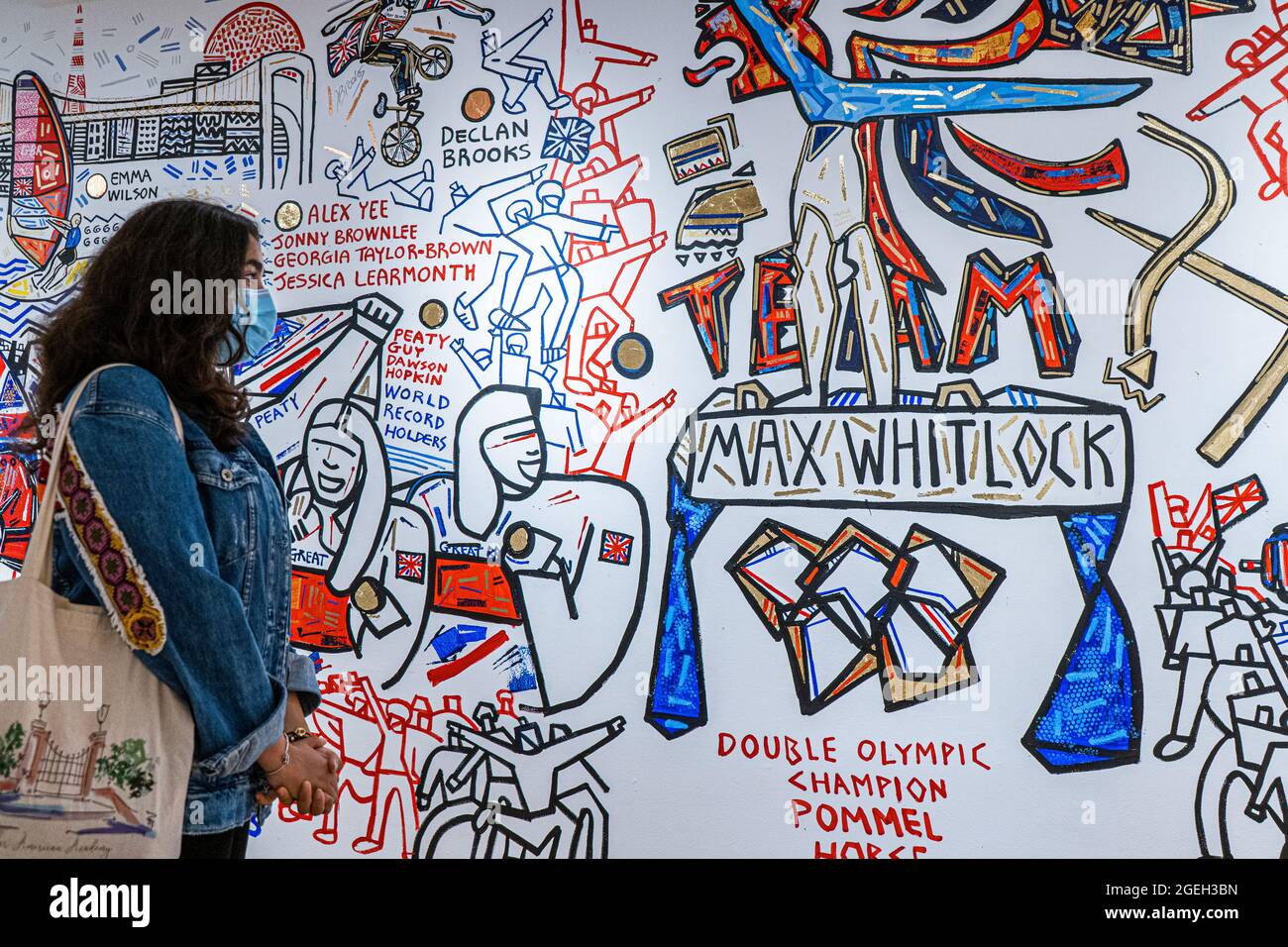 LONDRES, Royaume-Uni 20 août 2021. Les membres du public voient la fresque murale terminée qui trace la réussite des athlètes de l'équipe de Grande-Bretagne (GB) aux Jeux Olympiques de Tokyo en 2020. La fresque a été créée par Ben Mosley, un peintre d'action et expressionniste à l'atelier pop-up Team GB à Carnaby Street, qui a mis à jour les succès des médailles des athlètes tout au long des Jeux Olympiques . Team GB est devenu la première équipe olympique à créer et à vendre sa propre gamme de jetons non fongibles (NFT) servant à la fois de marchandise pour commémorer l'occasion, et un exercice de marketing utile. Credit: amer ghazzal / Alamy Live News Banque D'Images