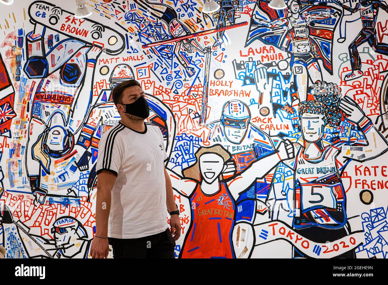LONDRES, Royaume-Uni 20 août 2021. Les membres du public voient la fresque murale terminée qui trace la réussite des athlètes de l'équipe de Grande-Bretagne (GB) aux Jeux Olympiques de Tokyo en 2020. La fresque a été créée par Ben Mosley, un peintre d'action et expressionniste à l'atelier pop-up Team GB à Carnaby Street, qui a mis à jour les succès des médailles des athlètes tout au long des Jeux Olympiques . Team GB est devenu la première équipe olympique à créer et à vendre sa propre gamme de jetons non fongibles (NFT) servant à la fois de marchandise pour commémorer l'occasion, et un exercice de marketing utile. Credit: amer ghazzal / Alamy Live News Banque D'Images