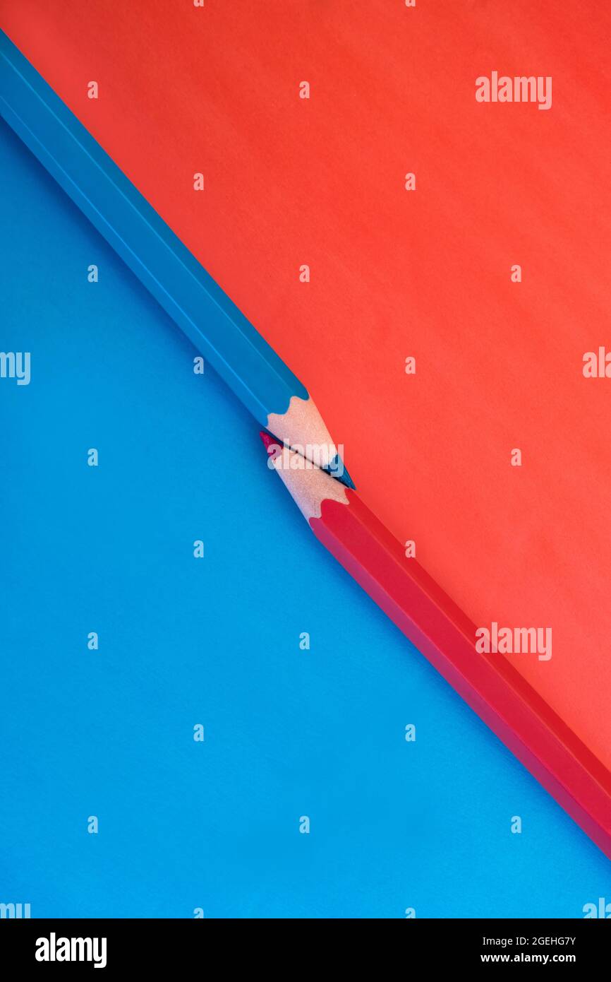 Photo macro de deux crayons de couleur rose et bleu vif avec les pointes touchant sur un fond assorti avec des couleurs opposées. Plan d'étapage avec vue de dessus en bas Banque D'Images
