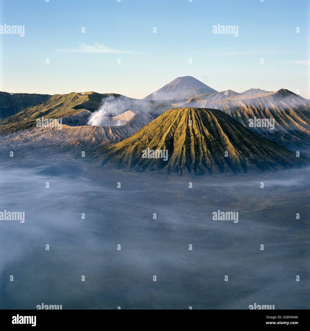 Soleil levant au-dessus du mont Bromo brumeux, parc national de Bromo Tengger Semeru, East Java, Java, Indonésie Banque D'Images