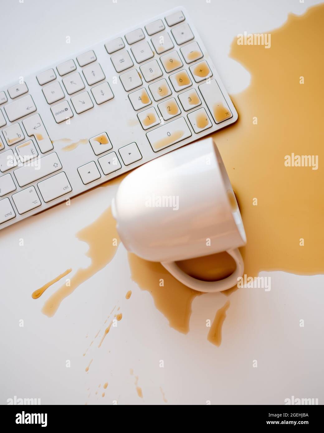 Café noir renversé sur un clavier d'ordinateur à un blanc tableau Banque D'Images Café noir renversé sur un clavier d'ordinateur à un blanc tableau Banque D'Images