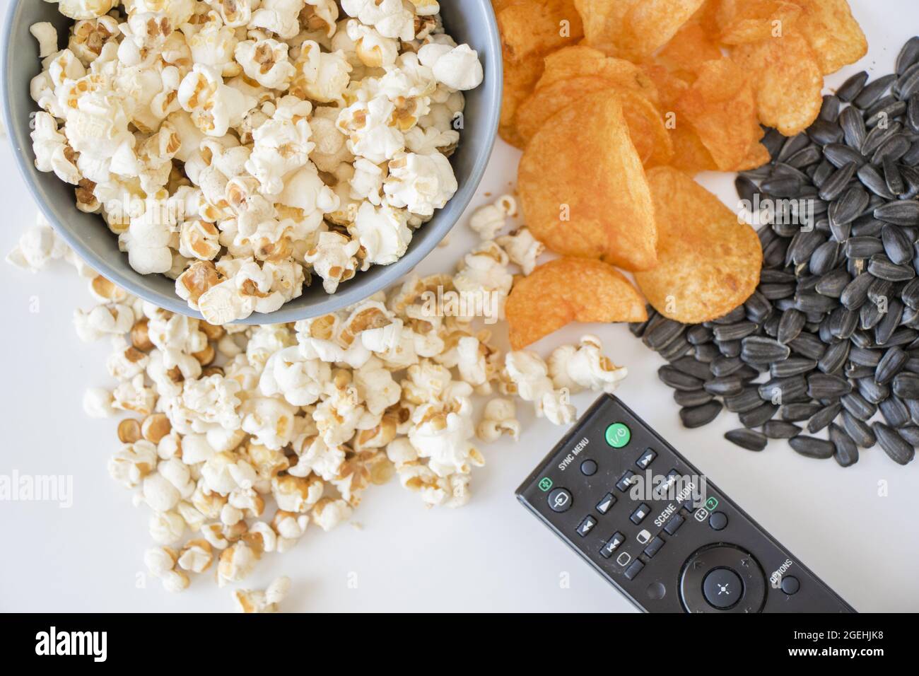 Pop-corn et une manette de télévision sur fond blanc Banque D'Images