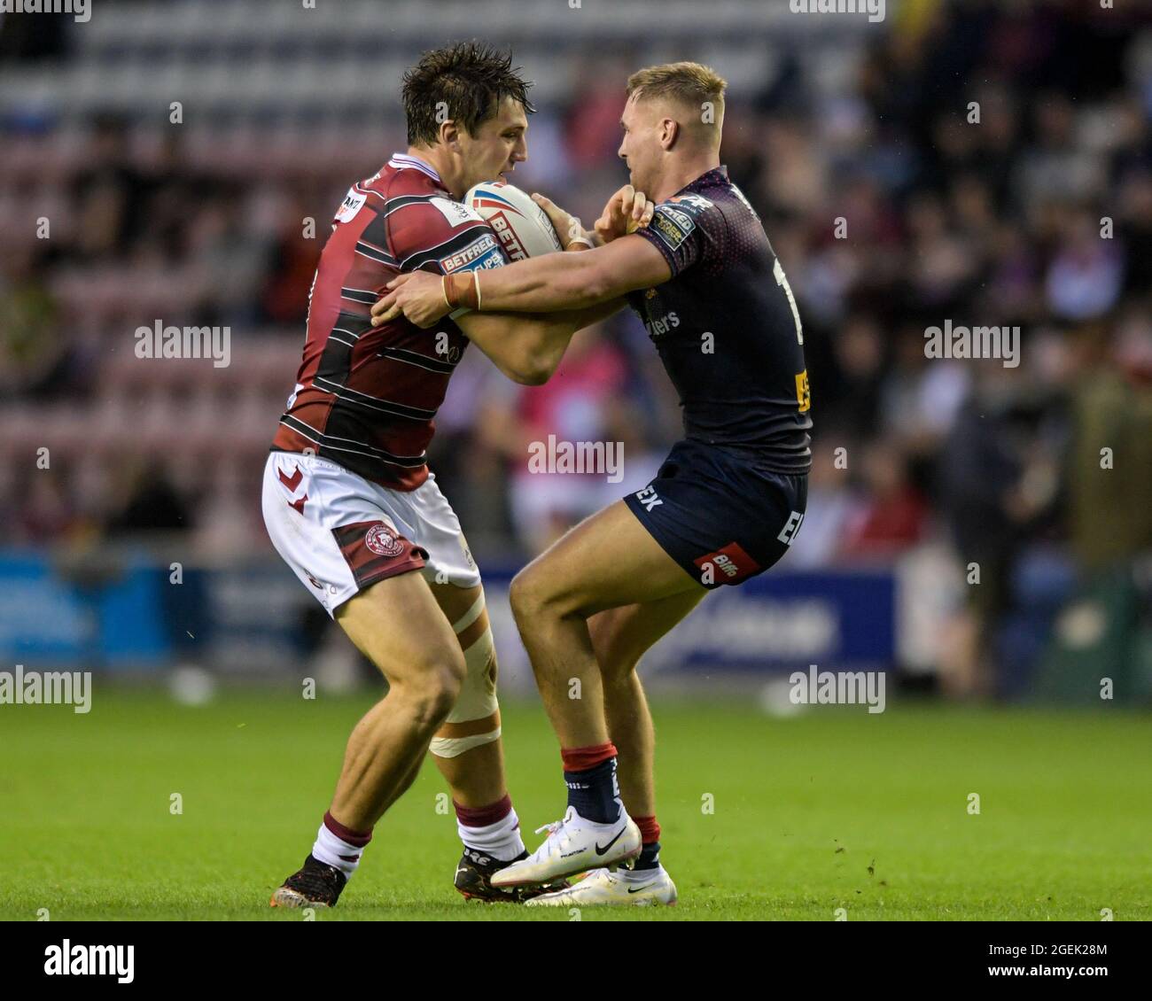 Liam Byrne (19) de Wigan Warriors et Matty Lees (10) de St Helens se disputent le ballon Banque D'Images