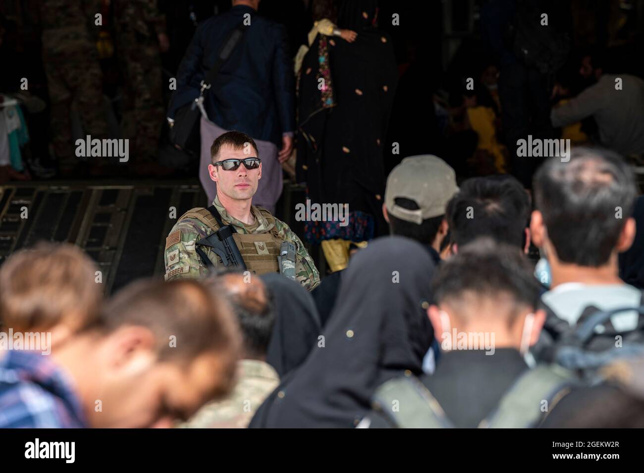 Kaboul, Afghanistan. 20 août 2021. Un aviateur de la US Air Force assure la sécurité pendant que les évacués chargent dans un avion C-17 Globemaster III, pendant l'évacuation des non-combattants à l'aéroport international Hamid Karzaï, dans le cadre de l'opération alliés refuge, le 20 août 2021 à Kaboul, en Afghanistan. Credit: Planetpix/Alamy Live News Banque D'Images