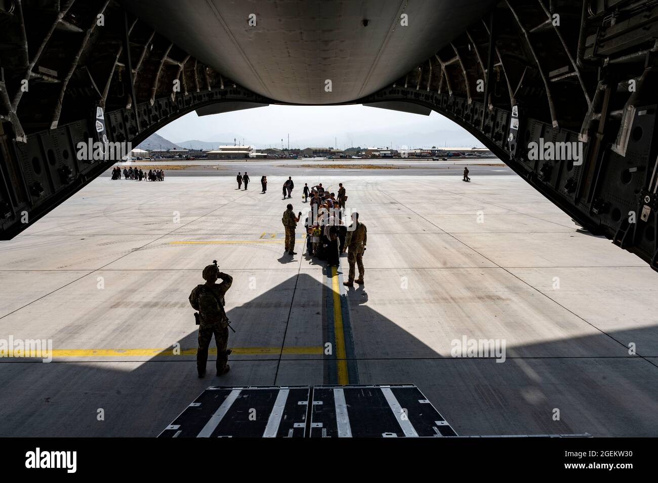 Kaboul, Afghanistan. 20 août 2021. L'aviateur de la Force aérienne américaine maintient la sécurité alors qu'il se prépare à charger des civils dans un avion C-17 Globemaster III, pendant l'évacuation des non-combattants à l'aéroport international Hamid Karzaï, dans le cadre de l'opération alliés refuge, le 20 août 2021 à Kaboul, en Afghanistan. Credit: Planetpix/Alamy Live News Banque D'Images