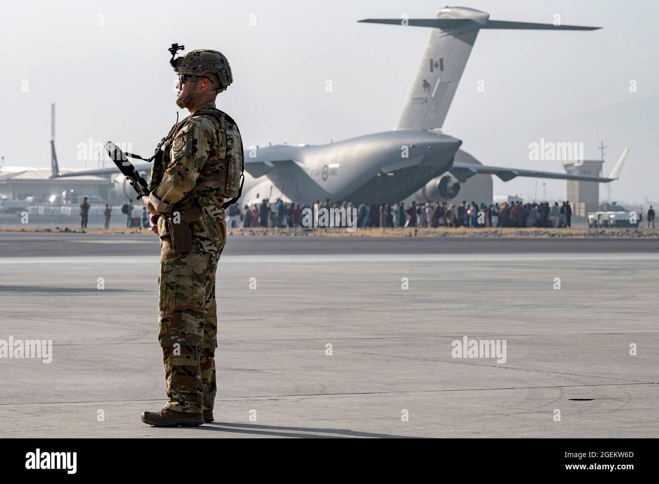 Kaboul, Afghanistan. 20 août 2021. Un aviateur de la US Air Force assure la sécurité pendant que les évacués chargent dans un avion C-17 Globemaster III, pendant l'évacuation des non-combattants à l'aéroport international Hamid Karzaï, dans le cadre de l'opération alliés refuge, le 20 août 2021 à Kaboul, en Afghanistan. Credit: Planetpix/Alamy Live News Banque D'Images