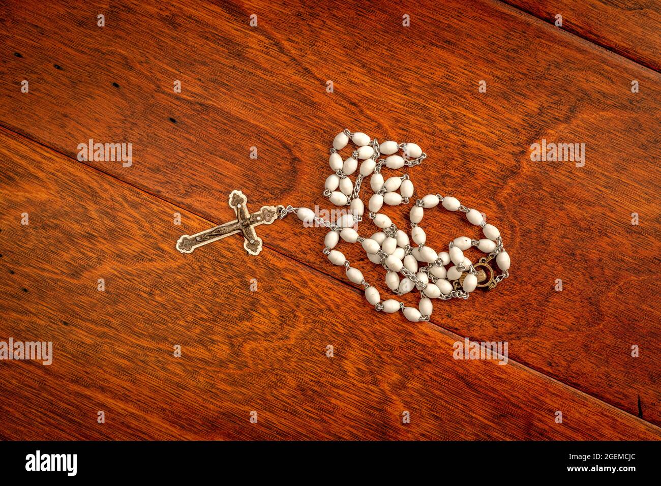 Un beau crucifix (corpus) et des perles sur une riche surface de podium en chêne avant un sermon. Banque D'Images