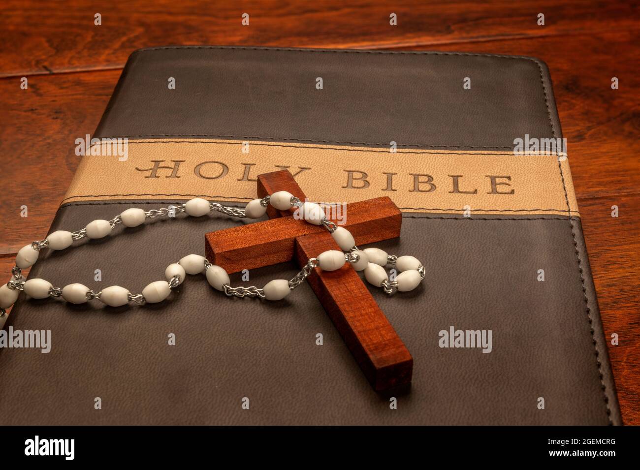 La croix religieuse d'un prêtre drapée de perles Crucifix repose sur une bible avant leur sermon. Banque D'Images