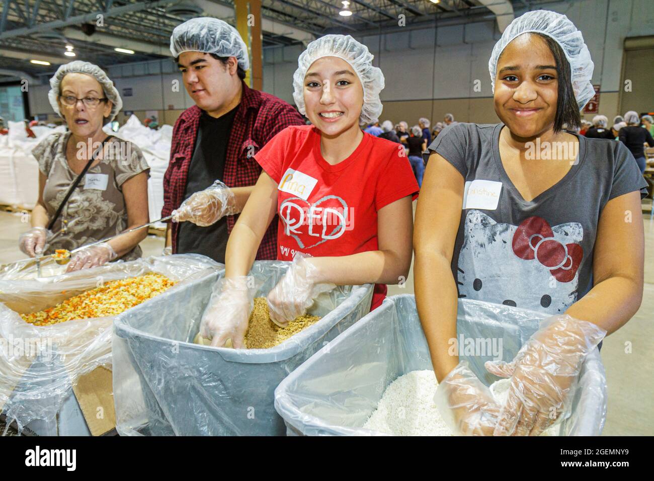 Miami Florida,Feed My Starving Children bénévoles bénévoles travailleurs, travail d'équipe travaillant ensemble pour l'emballage des repas portant des filets à cheveux filet, Hispa Banque D'Images