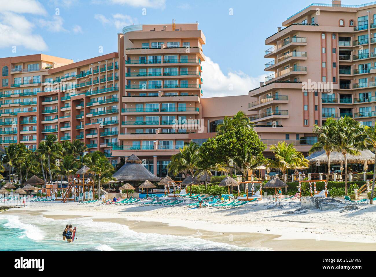 Mexique Yucatán Peninsula Cancun Beach Hotel zone Playa Caracol, mer des Caraïbes station balnéaire en bord de mer, Chikee chickee huts Waves les chaises longues d'eau Banque D'Images