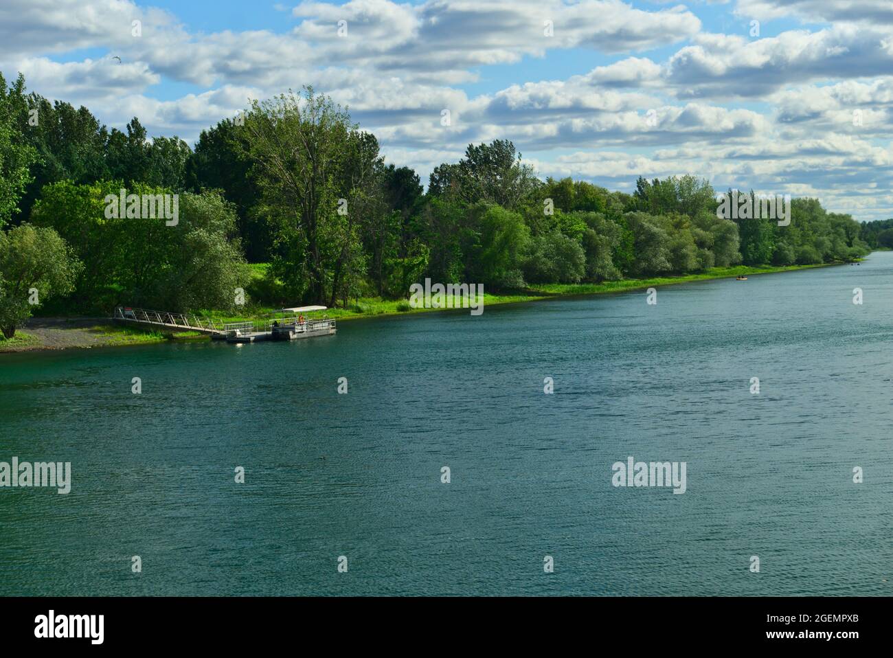 Un bateau dans la rivière entre les îles du parc national de Boucherville, dans le fleuve Lawrence (Laurent), Montréal, QC, par une journée d'été nuageux. Les arbres a Banque D'Images