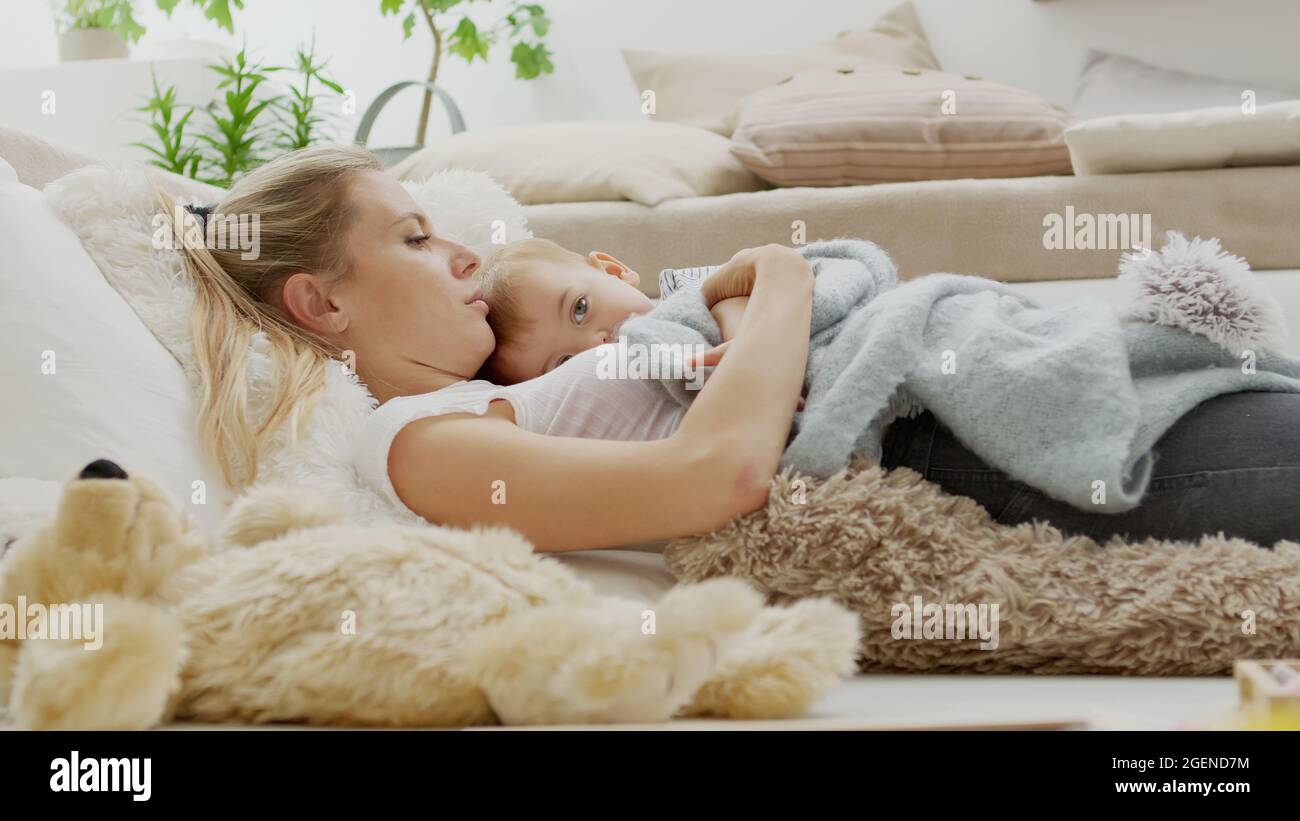 Une Maman Heureuse Calin Son Enfant Bebe De Fils Couche A La Maison Entre Les Oreillers Concept Sain Et Soigne Pour La Croissance Photo Stock Alamy