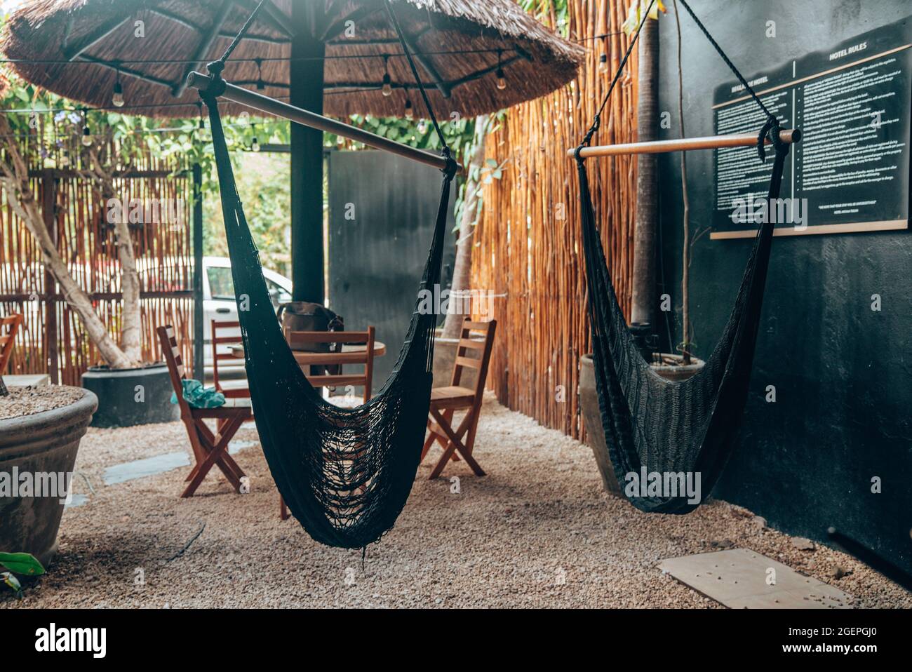 Chaise-balançoire suspendue avec table et chaise vides au café extérieur de  la plage Photo Stock - Alamy