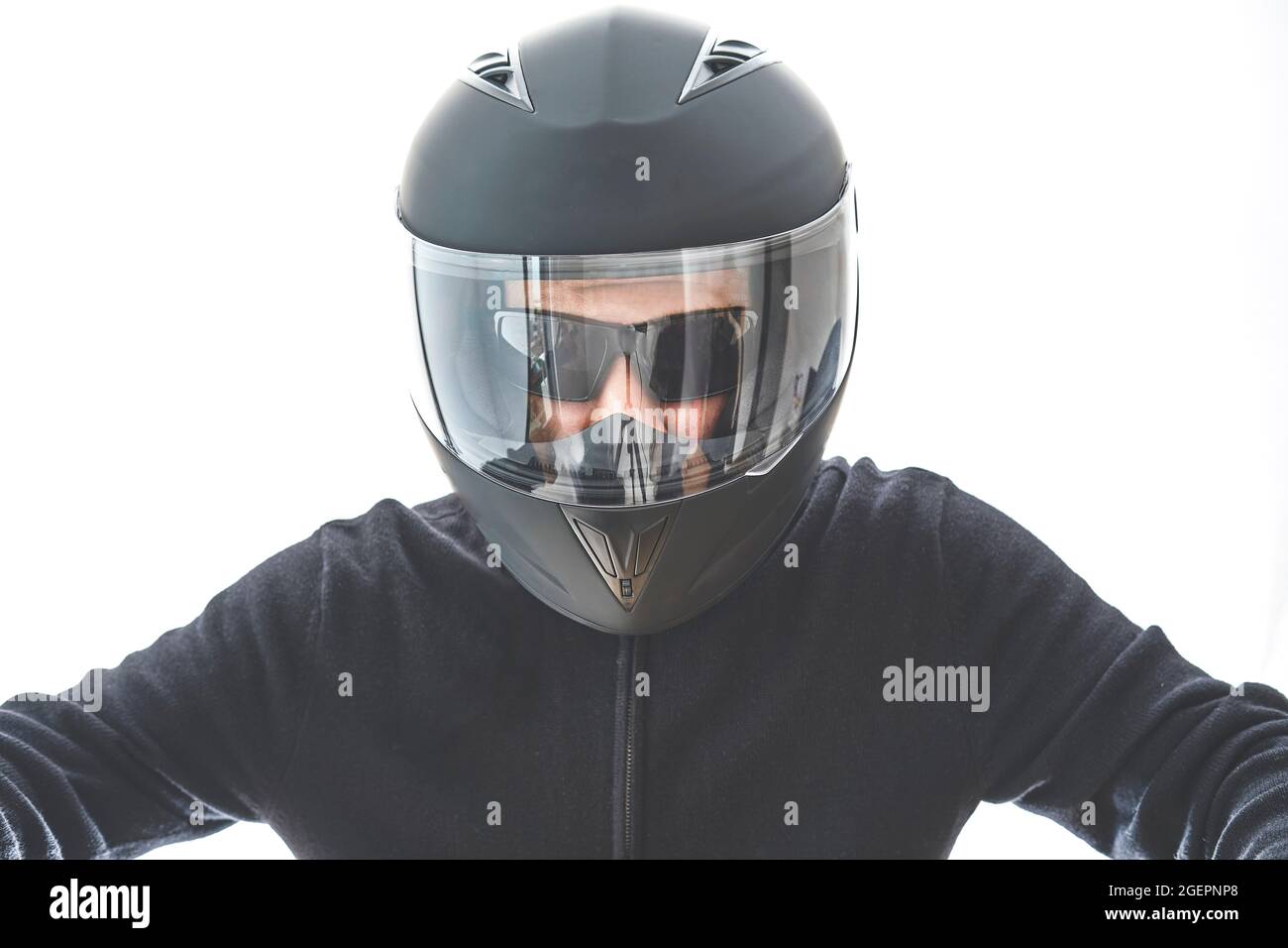 Portrait d'un homme avec une veste à carreaux noirs et un casque de moto  qui prétend conduire la moto. Isolé sur le mur blanc du studio Photo Stock  - Alamy
