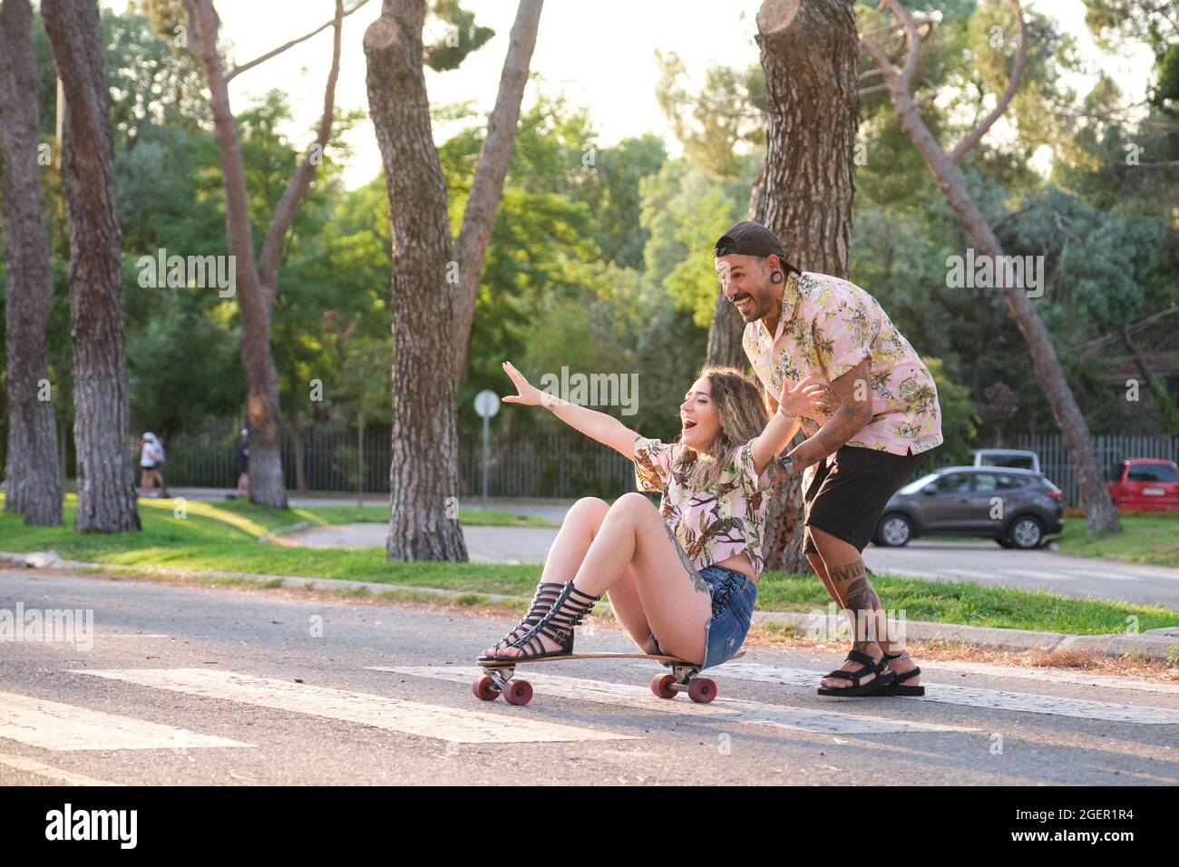 Jeune couple sympa tatoué ayant du skate amusant. Banque D'Images
