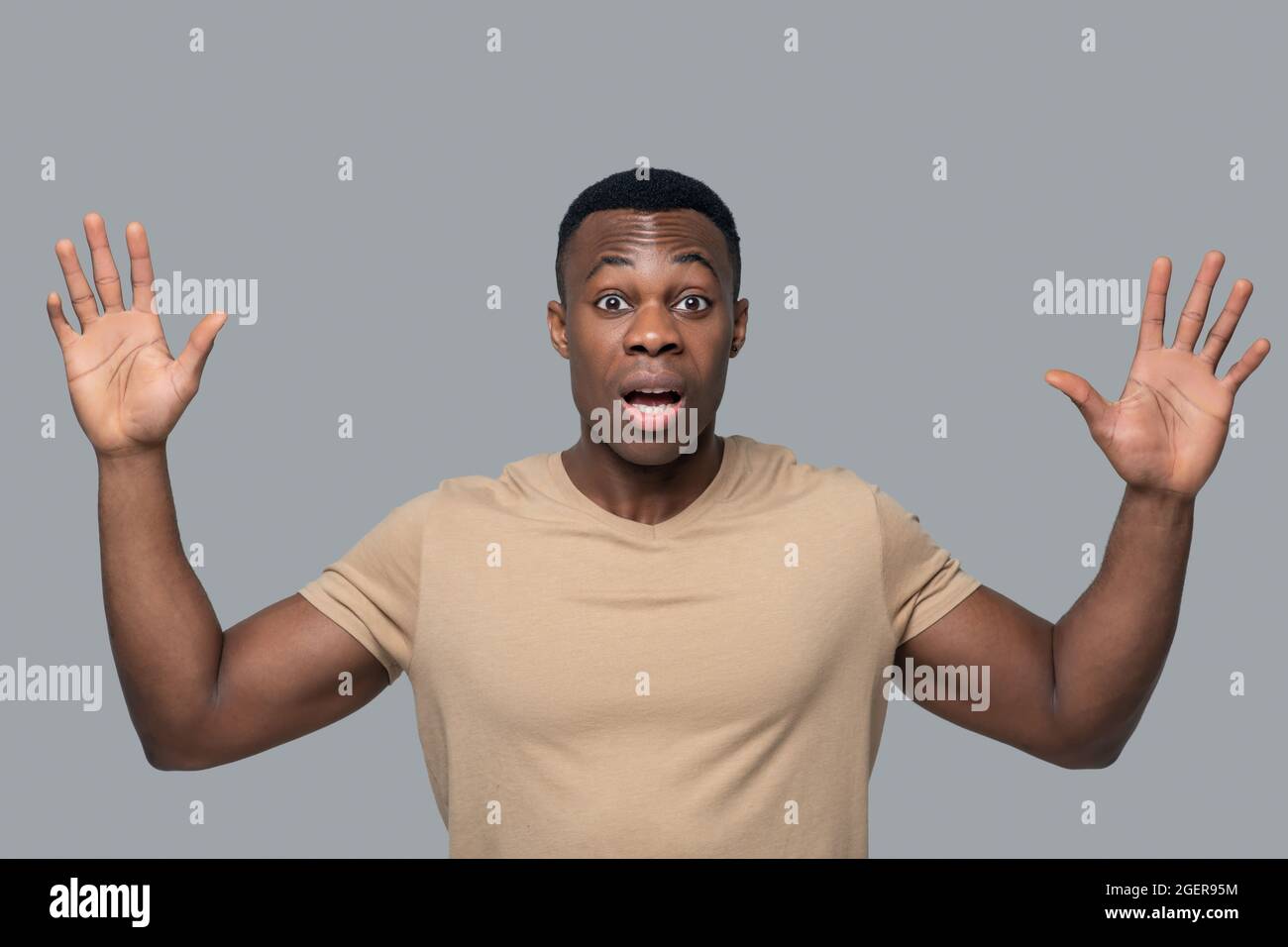 Jeune homme à la peau sombre qui a l'air surpris et choqué Banque D'Images