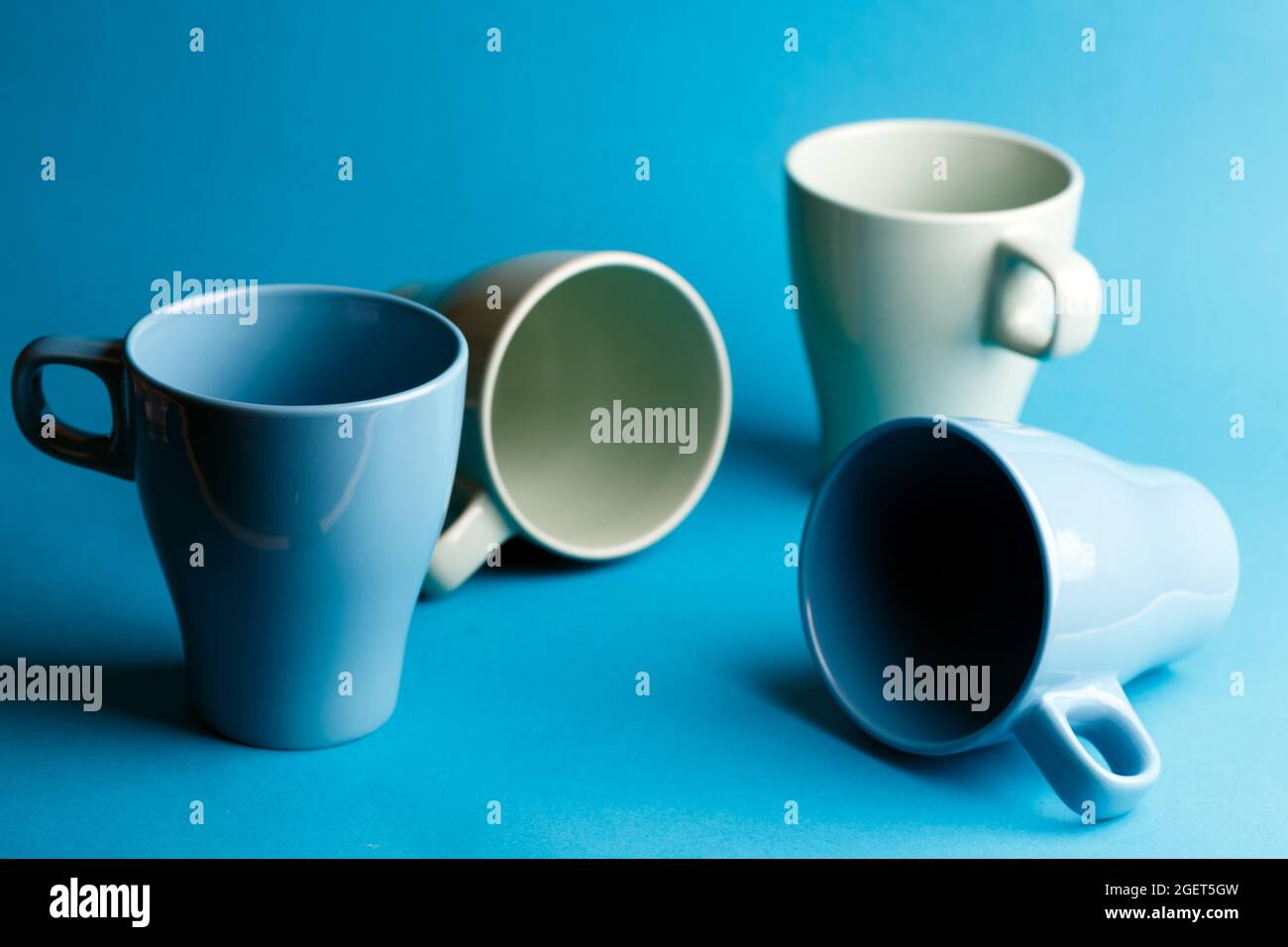 Céramique lumineux - tasses en couleurs bleu sur fond bleu Banque D'Images