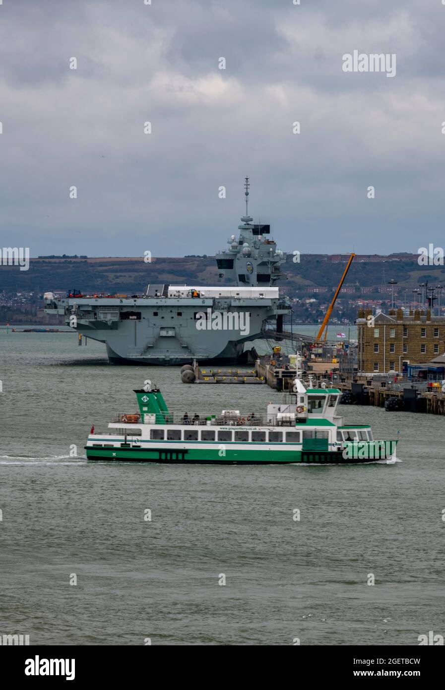 le ferry de gosport traversant le port de portsmouth, porte-avions de la marine royale, prince de galles, grand navire, marine royale, transports en commun, quai de portsmouth. Banque D'Images