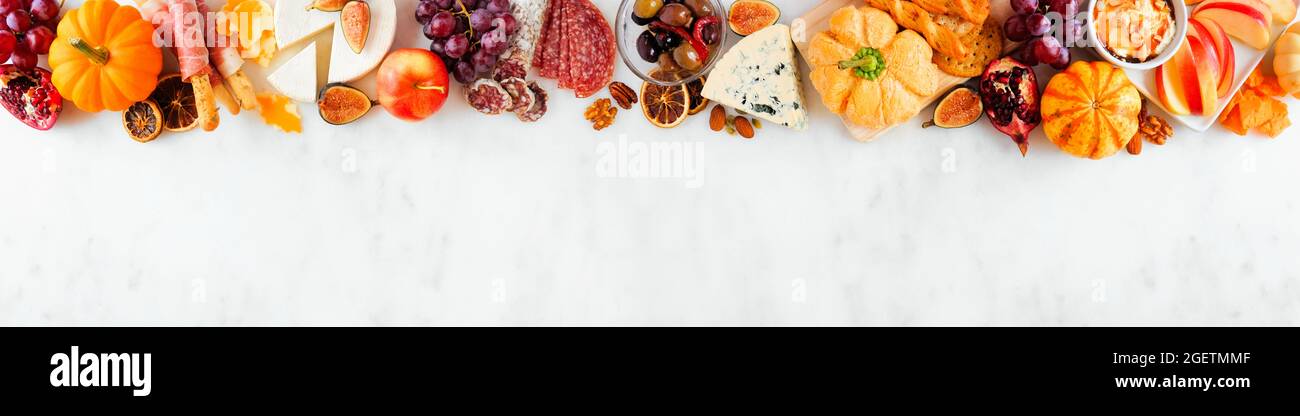 Bordure supérieure en forme de charcuterie d'automne sur fond de bannière en marbre blanc. Assortiment de fromages et hors-d'œuvre de viande. Copier l'espace. Banque D'Images