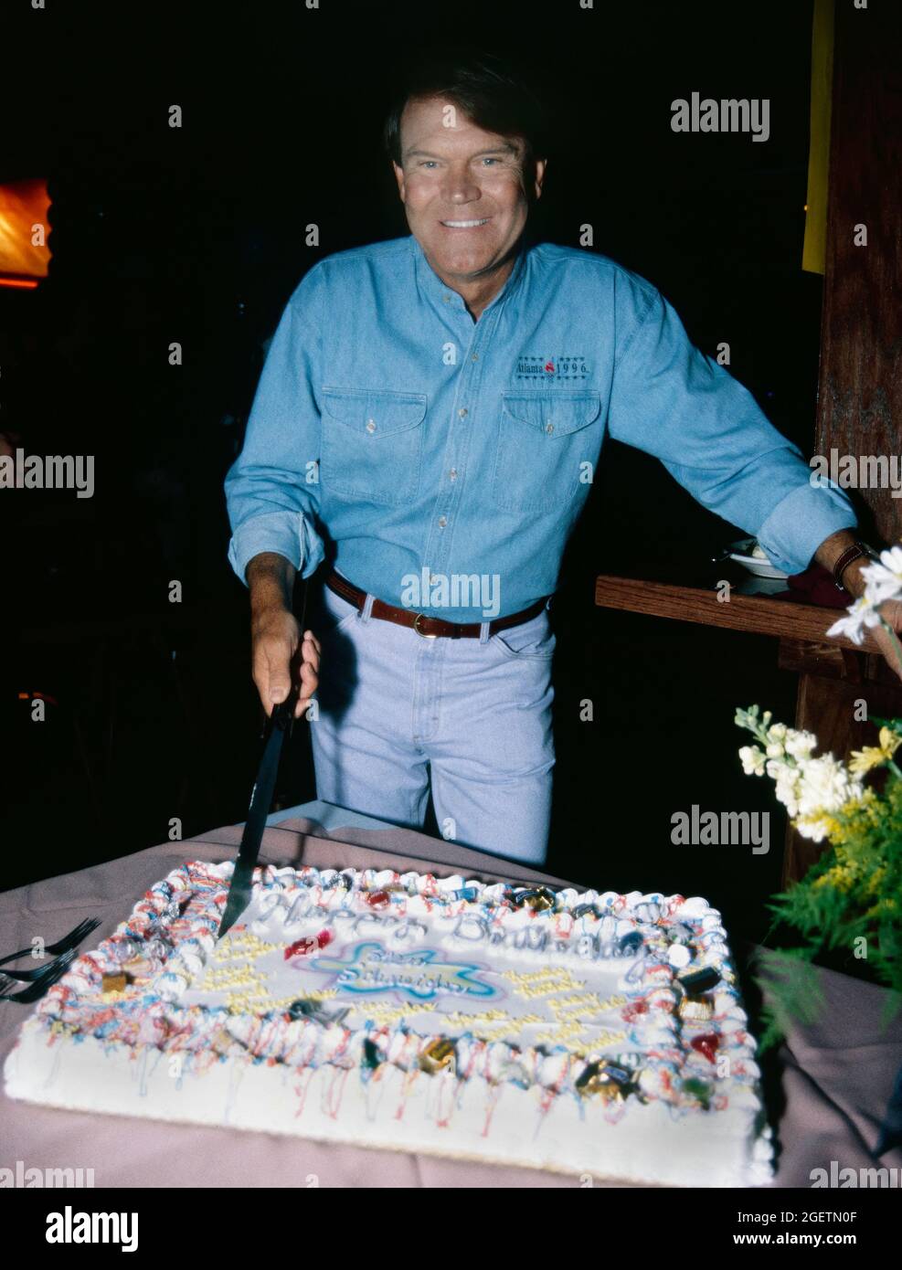 Glen Campbell Se Coupe Dans Son Gateau D Anniversaire Lors De Sa Celebration Surprise Du 60e Anniversaire Le 21 Avril 1996 A Branson Missouri La Date De Naissance Reelle De Glen Campbell Etait