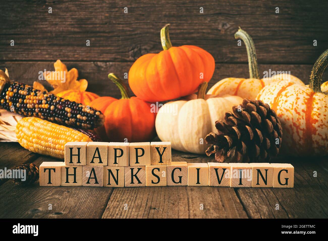 Joyeux Thanksgiving sur des blocs de bois sur un fond de bois rustique avec des citrouilles et un décor d'automne. Style vintage. Banque D'Images