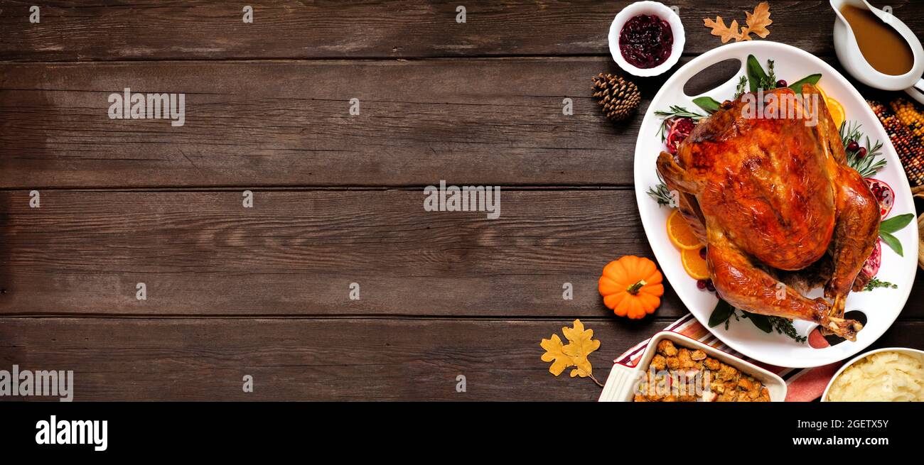 Dîner traditionnel de Thanksgiving avec dinde. Vue de dessus bordure latérale sur un arrière-plan de bannière en bois foncé avec espace de copie. Banque D'Images