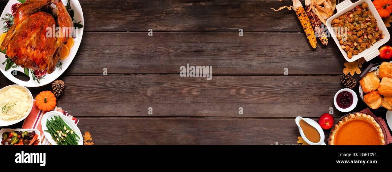 Dîner traditionnel de Thanksgiving avec dinde. Vue de dessus bordure double sur un arrière-plan de bannière en bois sombre avec espace de copie. Dinde, purée de pommes de terre, vinaigrette, pu Banque D'Images