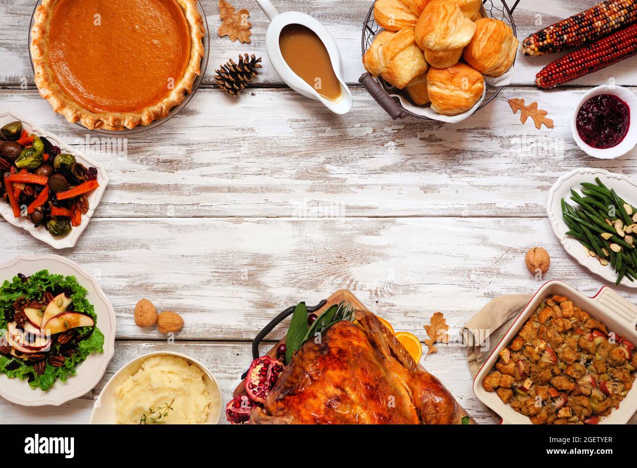 Dîner classique de Thanksgiving avec dinde. Cadre de vue de haut en bas sur un arrière-plan rustique en bois blanc avec espace de copie. Dinde, purée de pommes de terre, vinaigrette, citrouille Banque D'Images