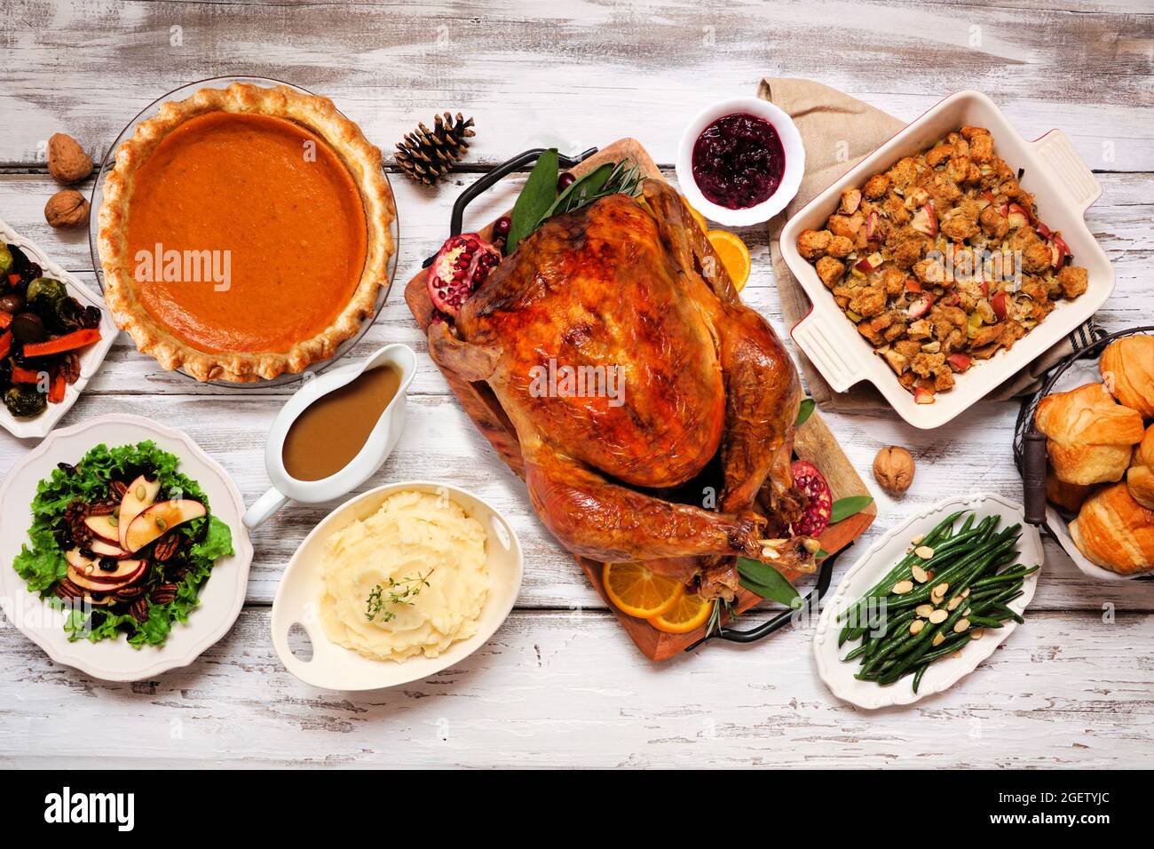 Dîner classique de Thanksgiving avec dinde. Table avec vue sur le dessus sur fond de bois blanc rustique. Dinde, purée de pommes de terre, farce, tarte à la citrouille et si Banque D'Images