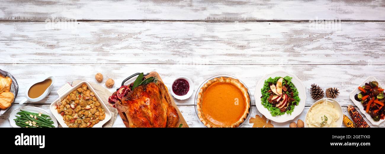 Dîner classique de Thanksgiving avec dinde. Au-dessus de la vue, bordure inférieure sur un arrière-plan rustique de bannière en bois blanc avec espace de copie. Dinde, purée de pommes de terre, farci Banque D'Images