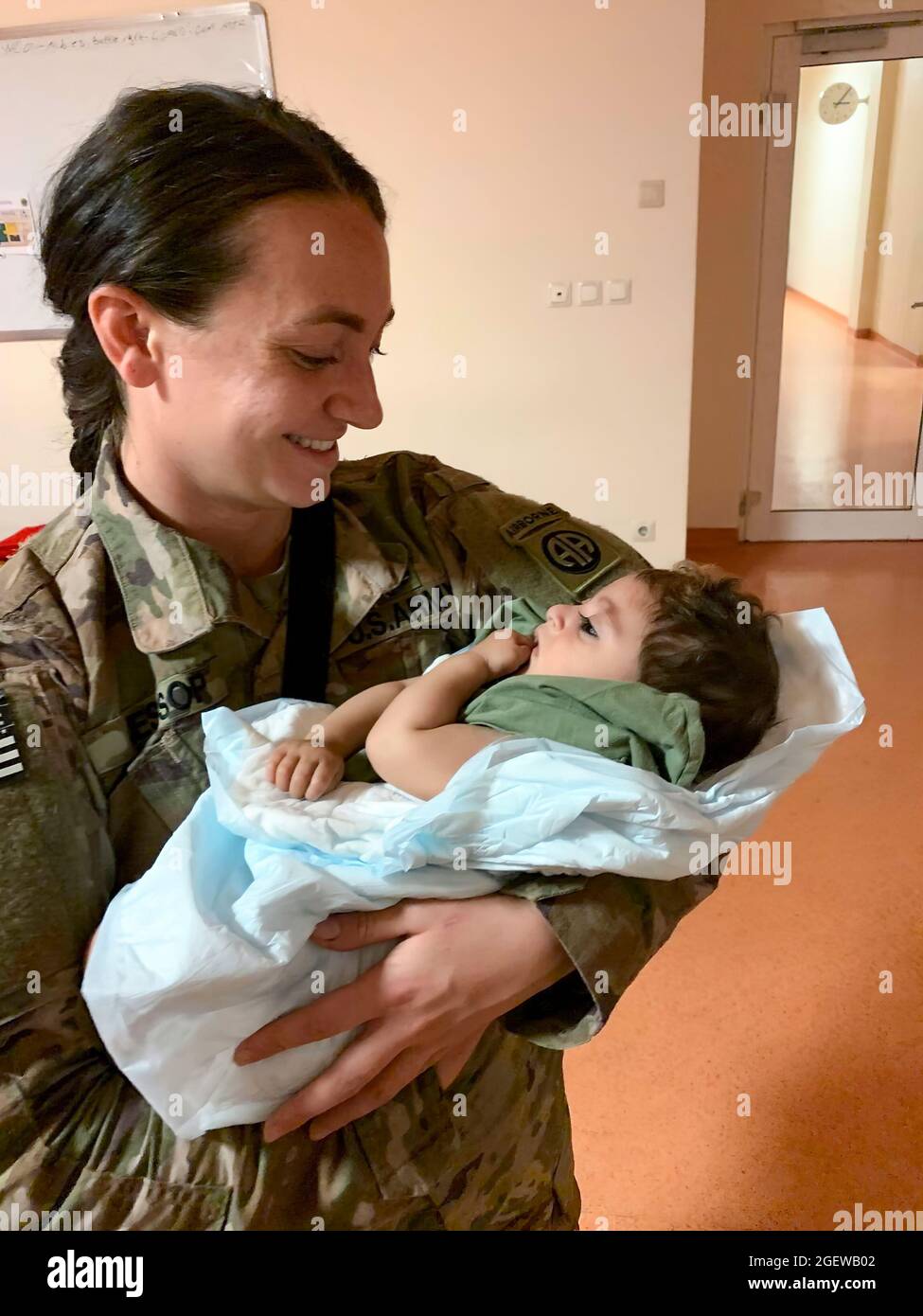 Le Sergent Breanna Jessop, un chef de la 82e division aéroportée du XVIII Airborne corps, s'occupe d'un enfant afghan à l'aéroport international Hamid Karzaï, en août 20. Banque D'Images