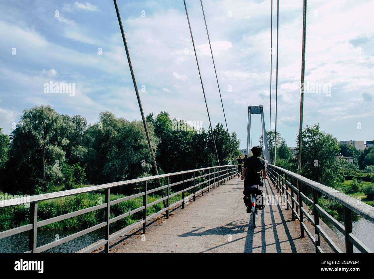 Vélo sur un pont, nature, ciel nuageux, extérieur, arbres verts Banque D'Images