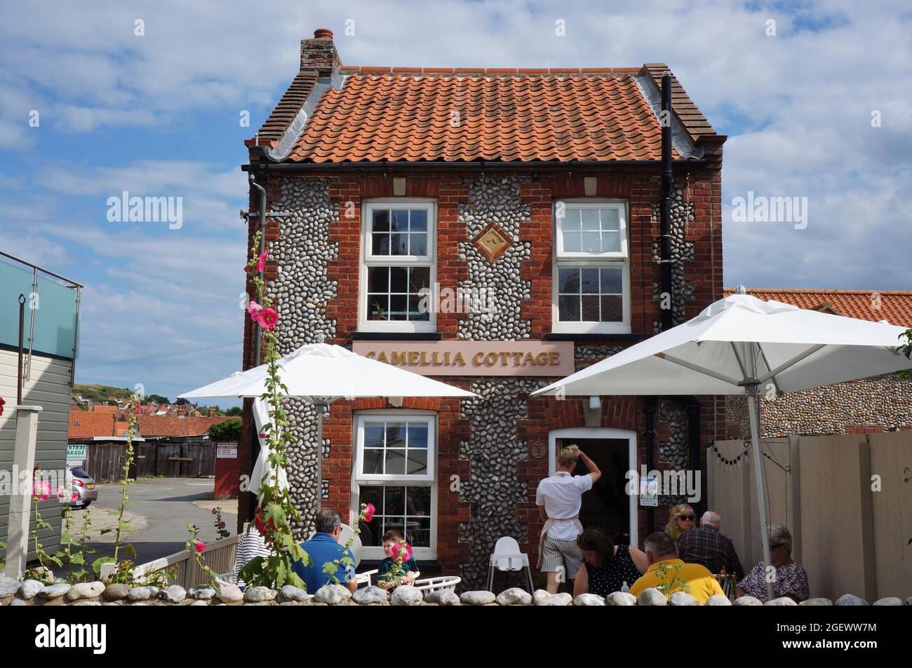 Les gens assis à l'extérieur de Camellia Cottage : un café par une journée ensoleillée à Sheringham Norfolk Banque D'Images