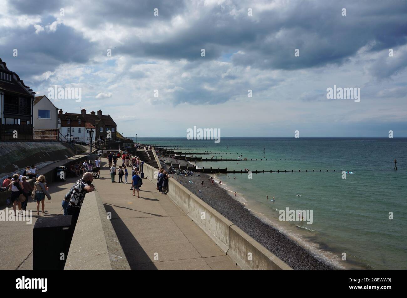 Le front de mer à Sheringham avec les gens qui profitent du soleil Banque D'Images