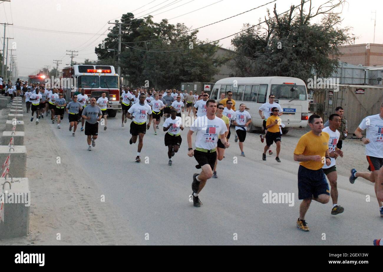 Les membres du service des incendies de Bagram courent en pleine vitesse lors d'un événement de course/marche de 5 km qui a eu lieu au terrain d'aviation de Bagram, en Afghanistan, le 12 septembre 2013. L'événement a eu lieu pour honorer et se rappeler les vies perdues pendant les attaques du 11 septembre 2001 contre les États-Unis et ceux qui ont payé le sacrifice ultime luttant pour la liberté. Plus de 1,200 coureurs et marcheurs ont participé à la course Patriot. Le nombre de participants a dépassé tout autre événement de course/marche auquel le BAF a assisté jusqu'à présent. (É.-U. Photo de la Garde nationale de l'armée par le Sgt. Anita VanderMolen) Banque D'Images