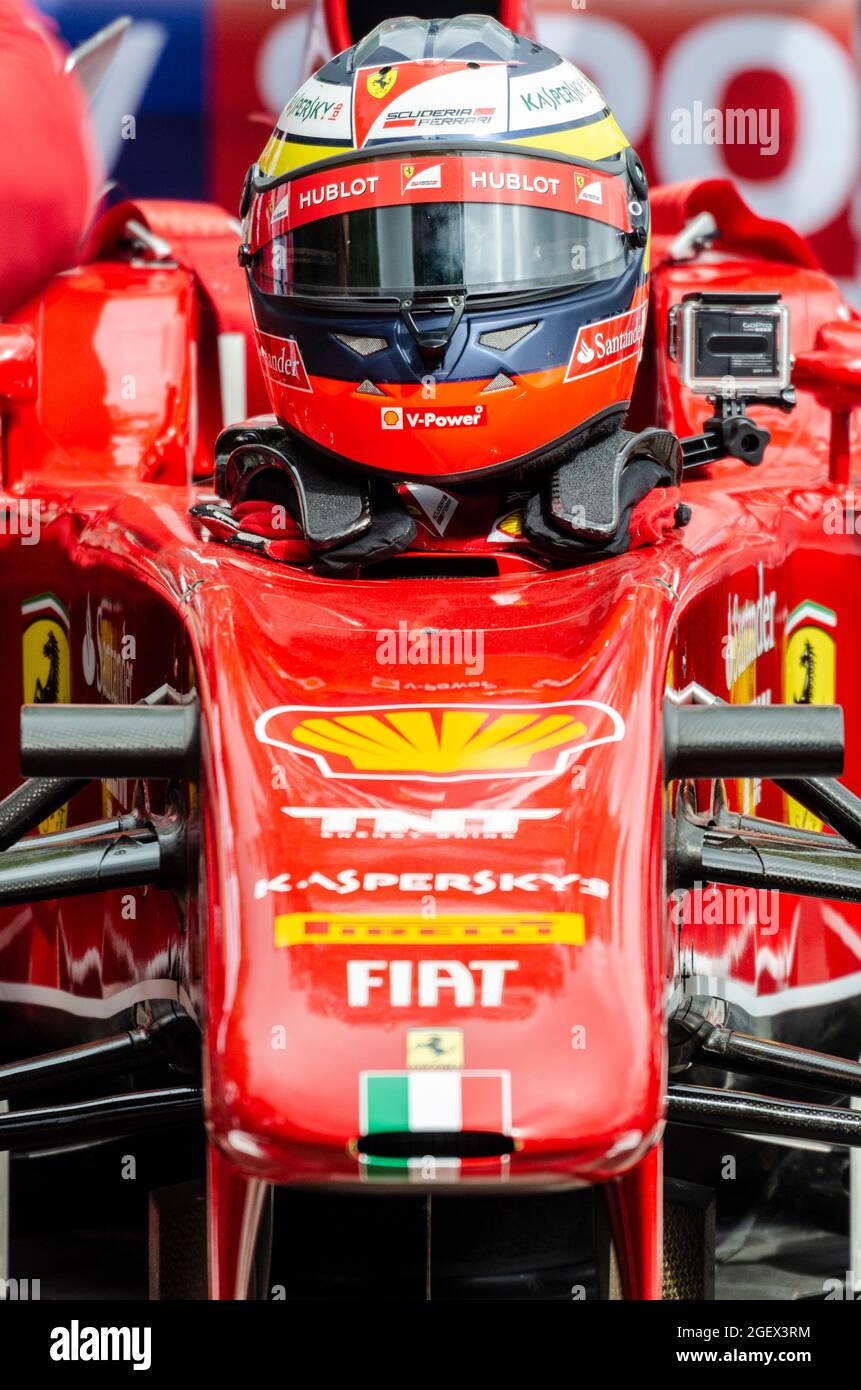 Pilote dans une Ferrari F60 Formule 1, voiture de course Grand Prix se préparant à la course à Goodwood en haut de la colline. Scuderia Ferrari. Casque, sponsors Banque D'Images