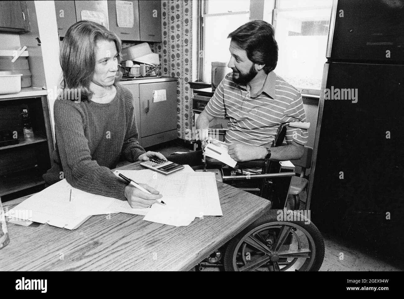 Austin Texas USA, vers 1992: Homme handicapé en fauteuil roulant et femme travaillent sur le budget du ménage de leur table de cuisine. ©Bob Daemmrich Banque D'Images